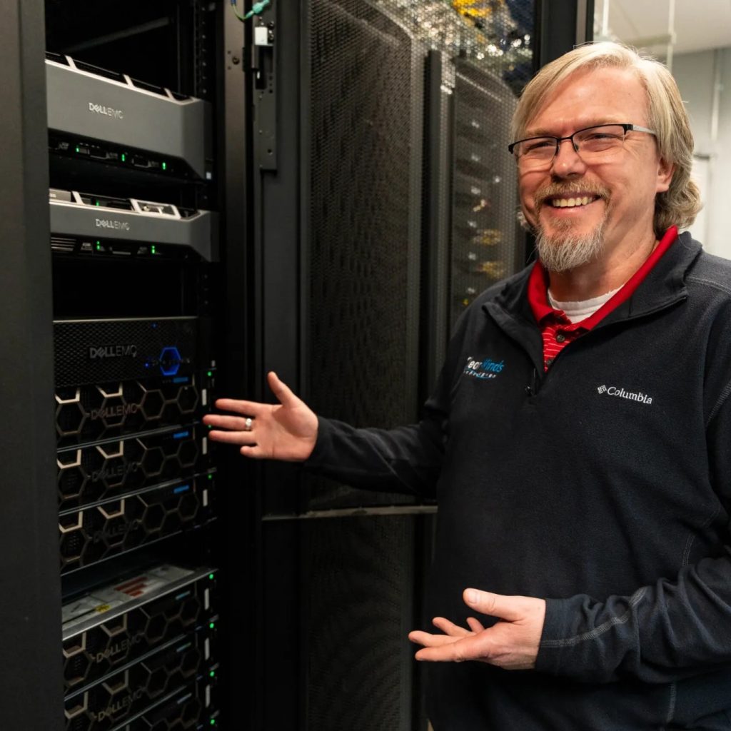 A Clear Winds hosted services team member with a server.