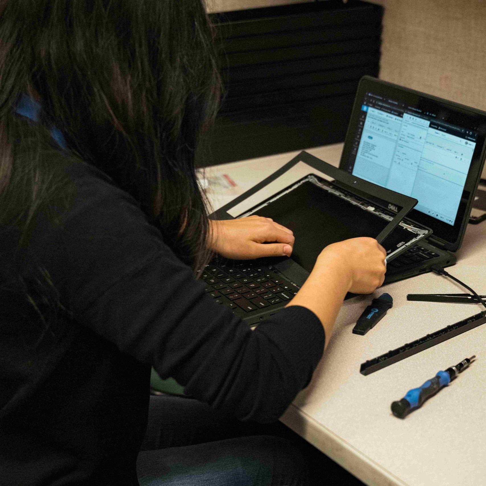 A repair technician working on a Chromebook