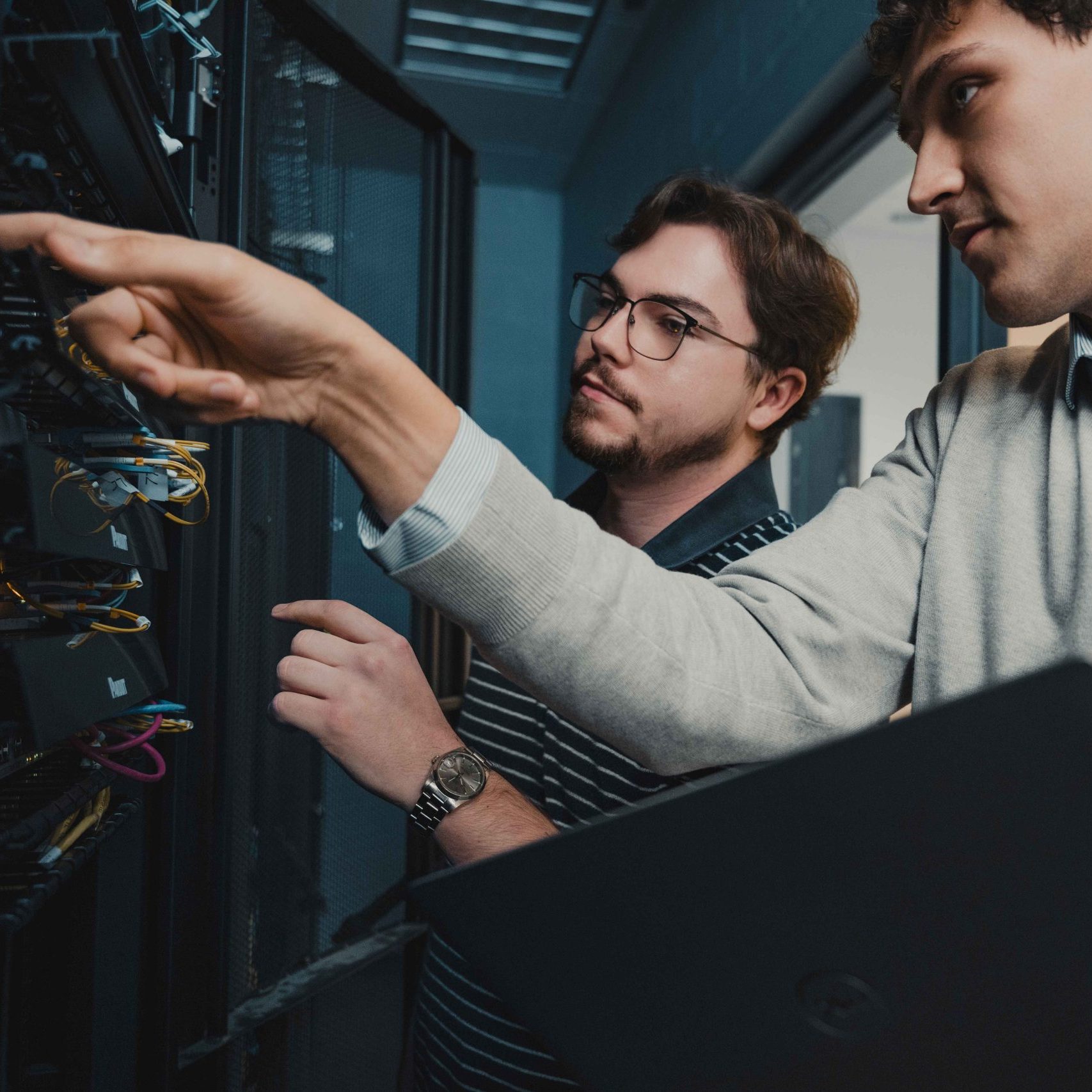 Two members of the cloud and hosting services in Nashville team with a server.