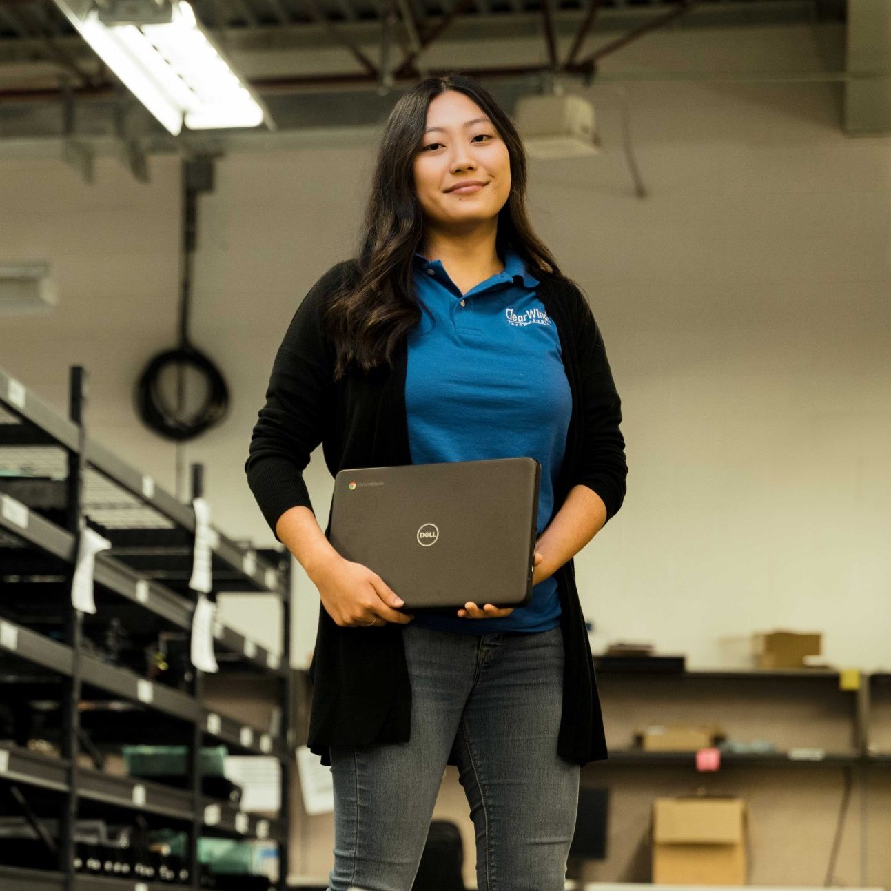A member of the Clear Winds cybersecurity team holding a laptop.