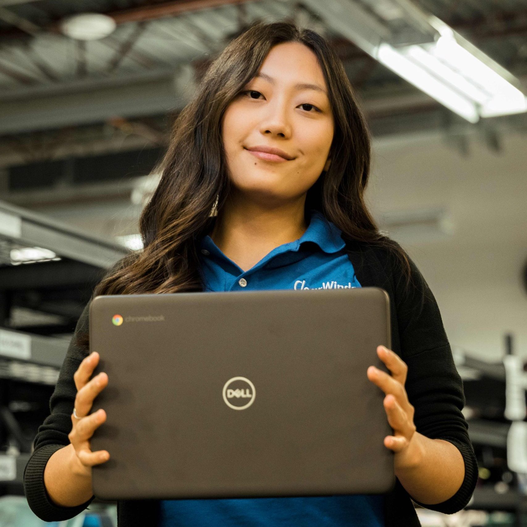 A member of the Clear Winds team holding a laptop.