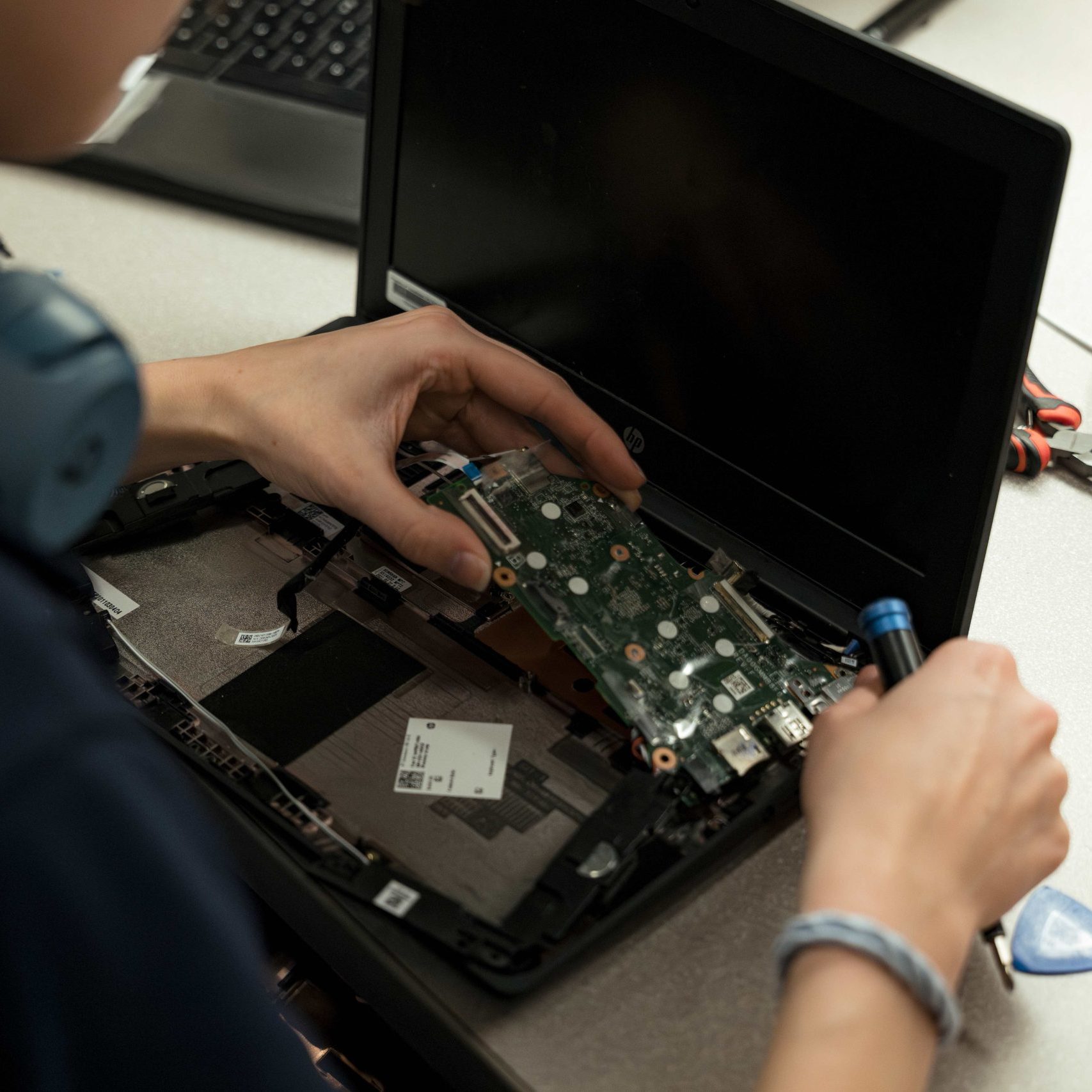 A member of the Clear Winds device repair team repairing a Chromebook.