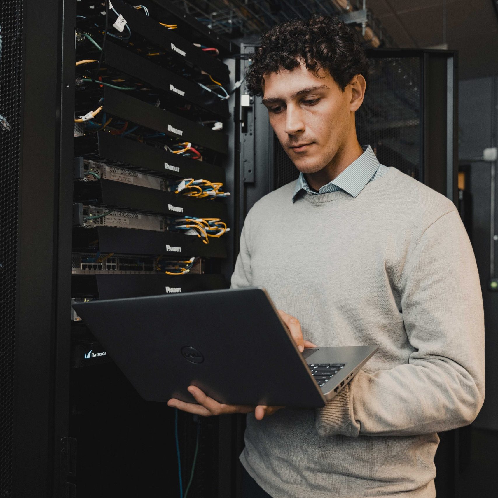 A member of the Clear Winds cybersecurity team with a laptop.