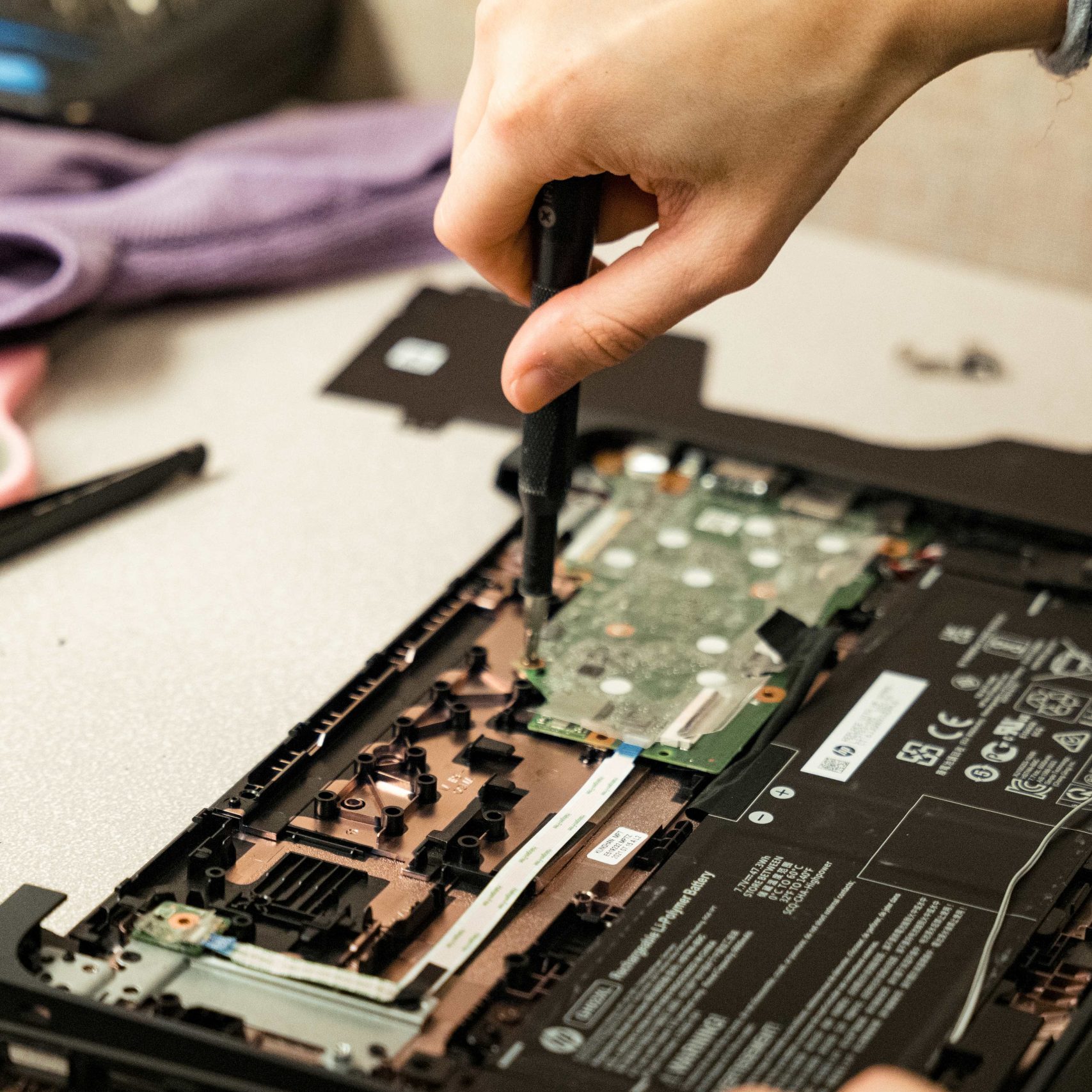 A Clear Winds team member repairing a Chromebook.