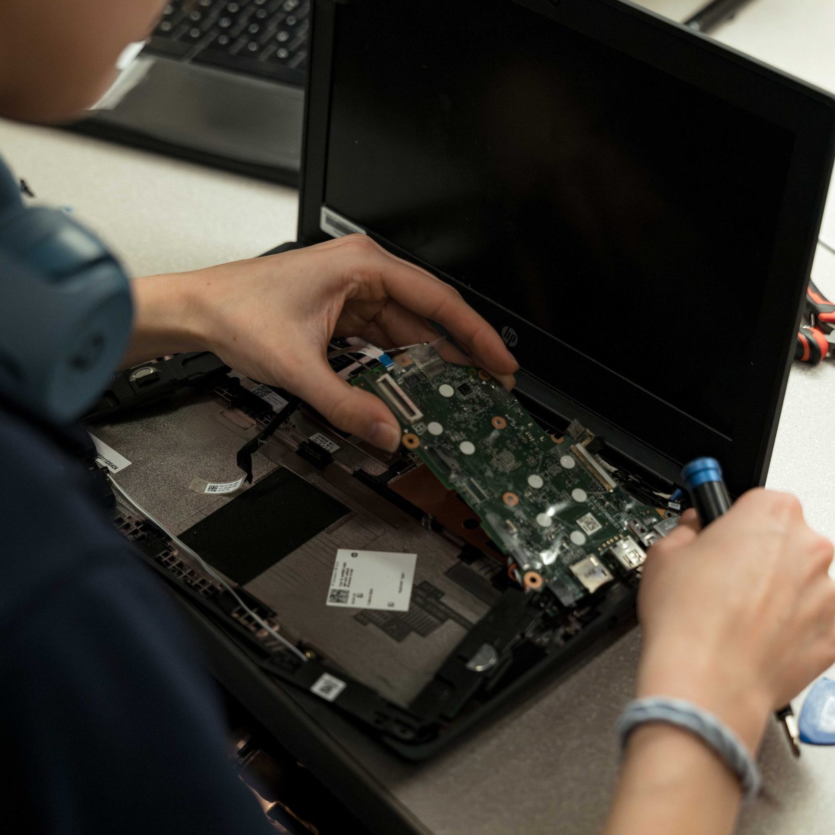 A Clear Winds team member repairing a Chromebook.