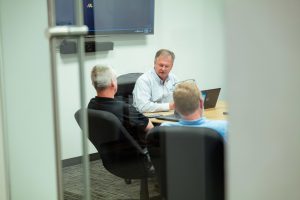 Team members meeting to discuss AI skepticism.